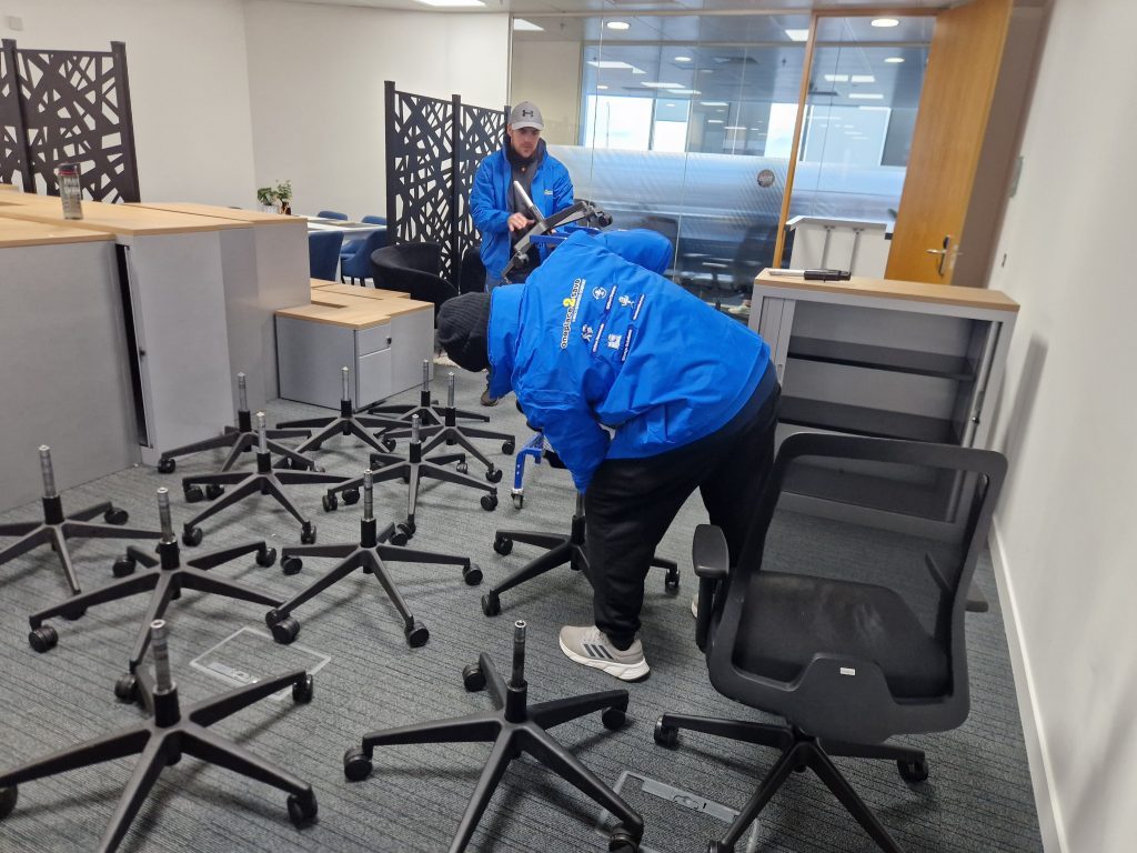 Oneplace2save team dismantling office chairs and preparing office furniture for removal during an office clearance.