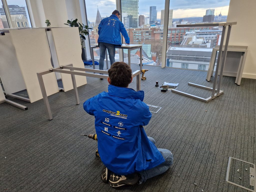 Oneplace2save team dismantling office desks and furniture during an on-site office clearance.
