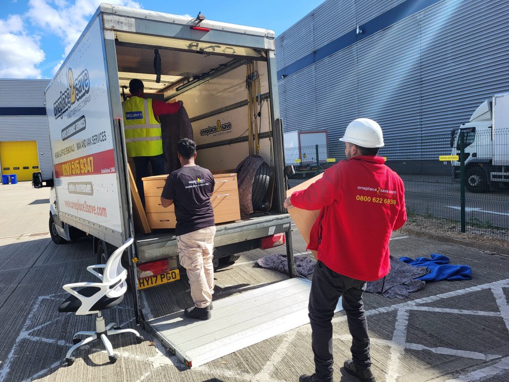 Oneplace2save team loading office furniture into a removal van using the tail lift for a smooth relocation.