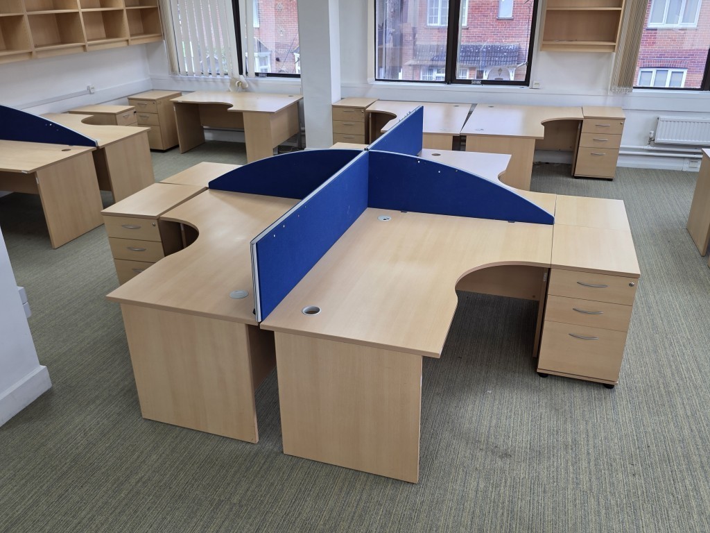 Used L-shaped office desk with a corner return in a workplace