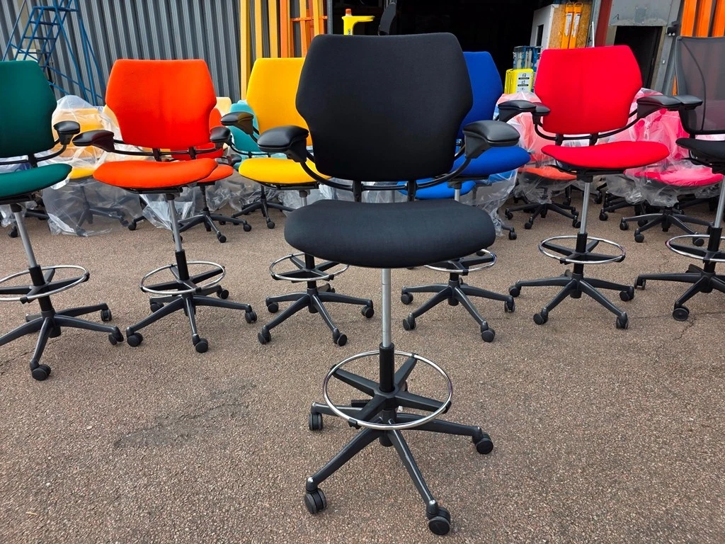 Used office chairs positioned at desks in a workplace