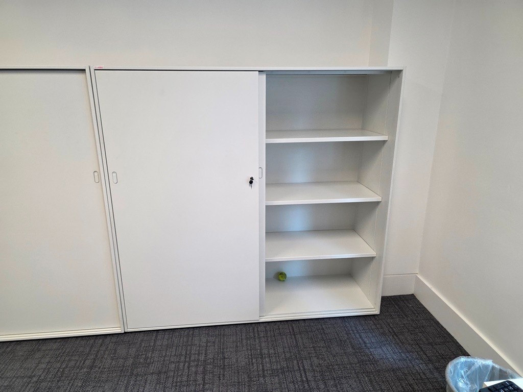 Used office cupboards with hinged sliding and tambour doors in a commercial office