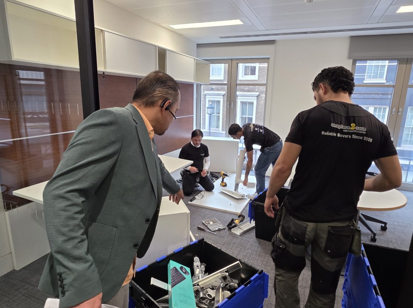 Team preparing an office move as desks are dismantled and fittings are sorted into crates